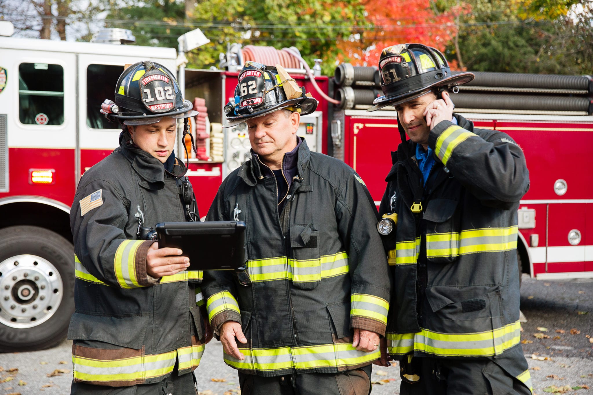 AT&T Firemen using digital tablet while other fireman talking on mobile phone