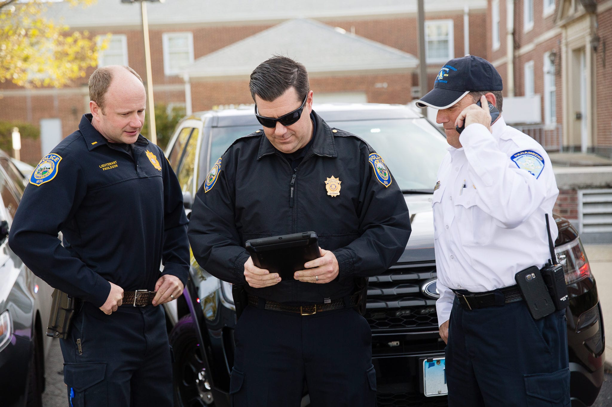 AT&T Policemen using digital tablet while another police officer talking on mobile phone